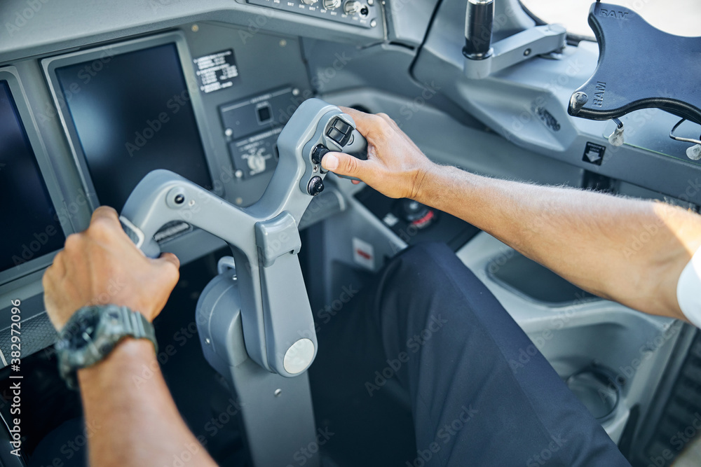 Male pilot in cockpit flying passenger plane
