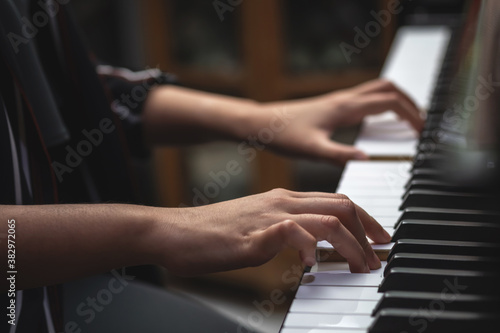 young woman performer hands playing piano.