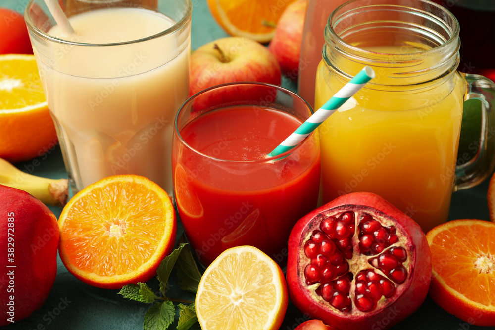 Concept of glasses and jars with different juices on green background Concept of glasses and jars with different juices on green background