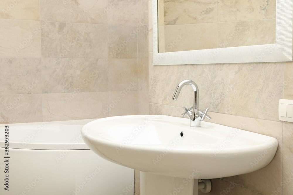 Fototapeta premium Sink in modern comfortable bathroom in light beige color