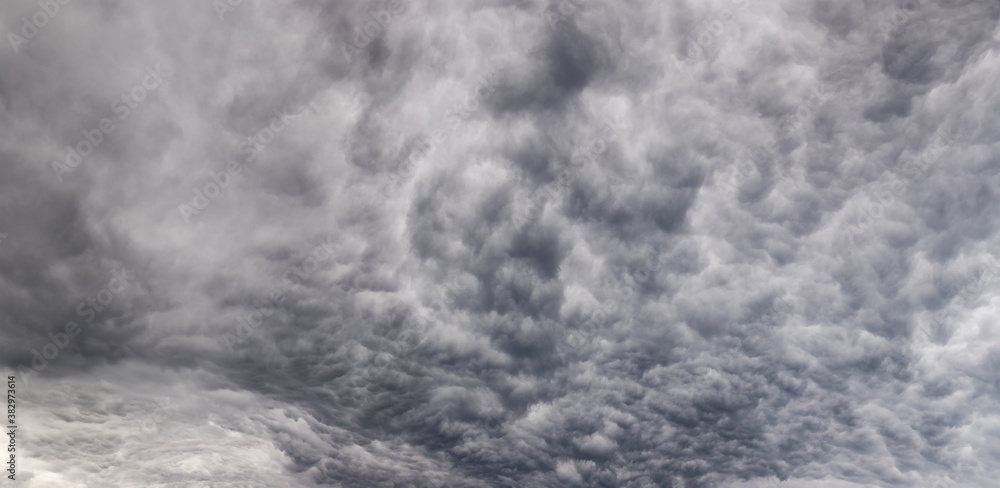 Obraz premium Panoramic view of a stormy sky fragment with dense clouds
