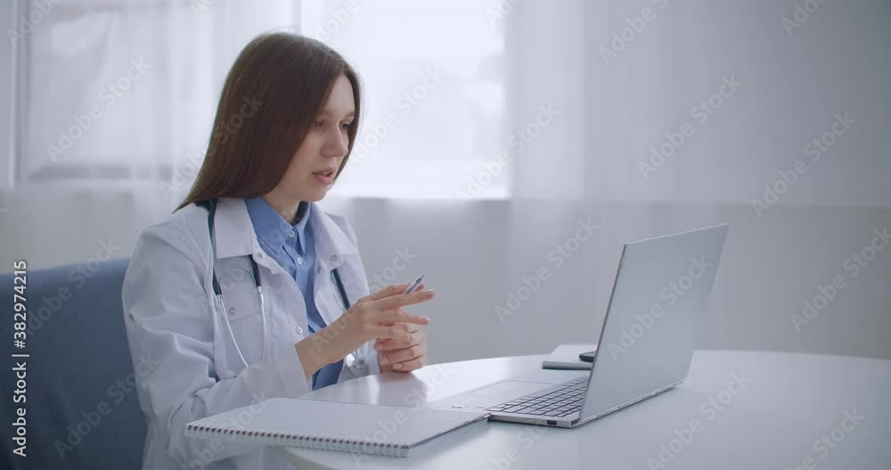 aged female family doctor is consulting online, talking with patient by video chat at laptop, working remotely aged female family doctor is consulting online, talking with patient by video chat at laptop, working remotely