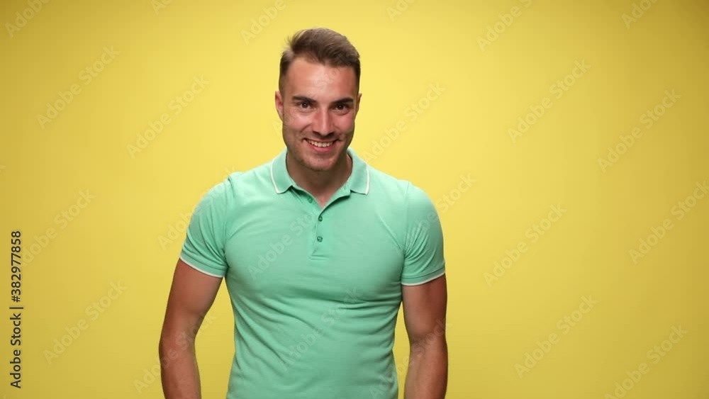 casual handsome man walking in and giving a thumbs up on yellow background casual handsome man walking in and giving a thumbs up on yellow background