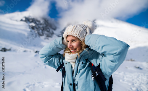 Portrait of happy smiling woman standing in snowy winter nature.