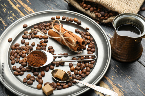 Pot with coffee, beans, powder and spices on table