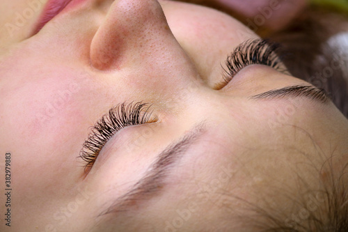 Eyelash extension procedure, woman eye with Long eyelashes © tcsaba