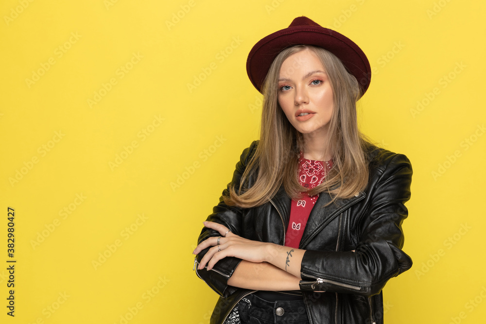Confident fashion model holding hands folded while wearing hat Confident fashion model holding hands folded while wearing hat