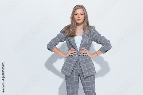 Tough fashion businesswoman holding hands on hips and wearing suit