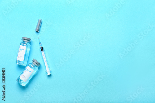 Bottles of insulin with syringe on color background. Diabetes concept
