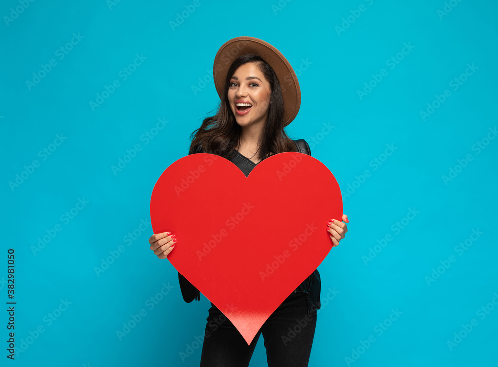 Positive casual woman holding heart shape and laughing Positive casual woman holding heart shape and laughing