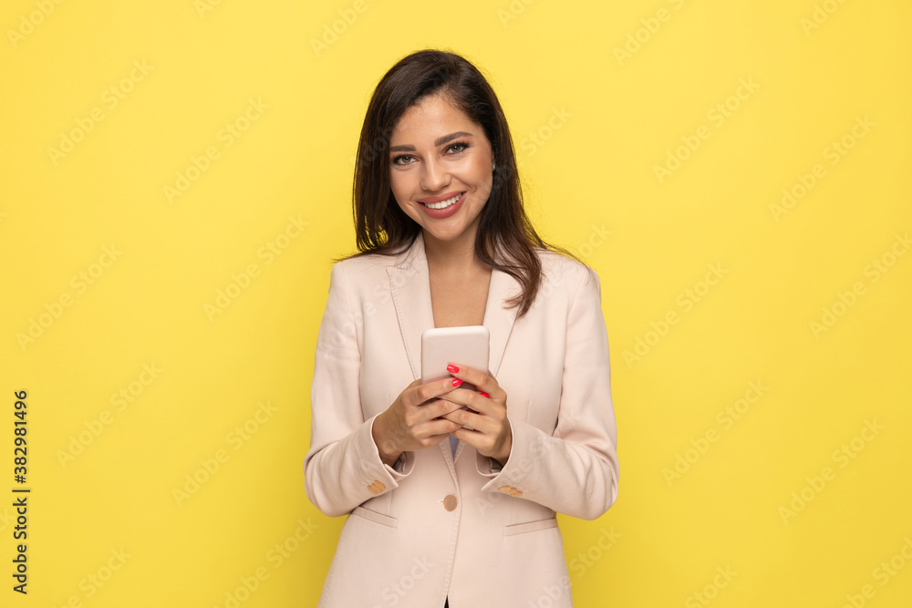 attractive young woman in pink suit holding phone attractive young woman in pink suit holding phone