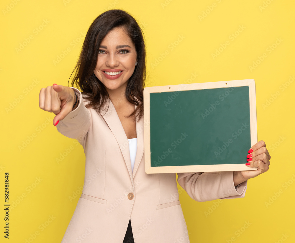happy young girl in pink suit smiling and pointing finger happy young girl in pink suit smiling and pointing finger