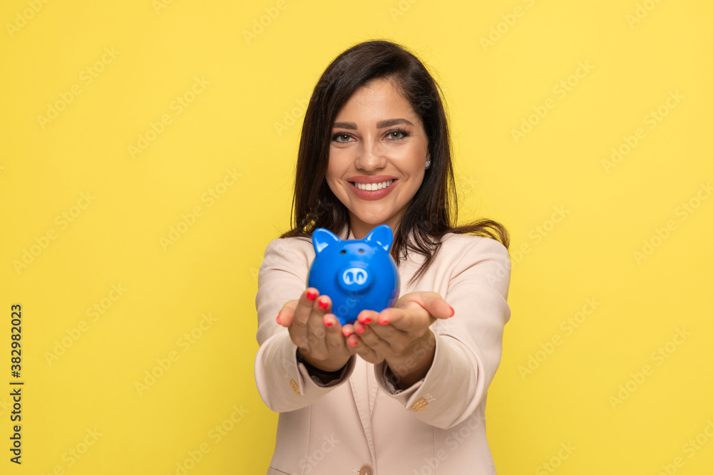 happy young businesswoman in pink suit showing piggy bank happy young businesswoman in pink suit showing piggy bank