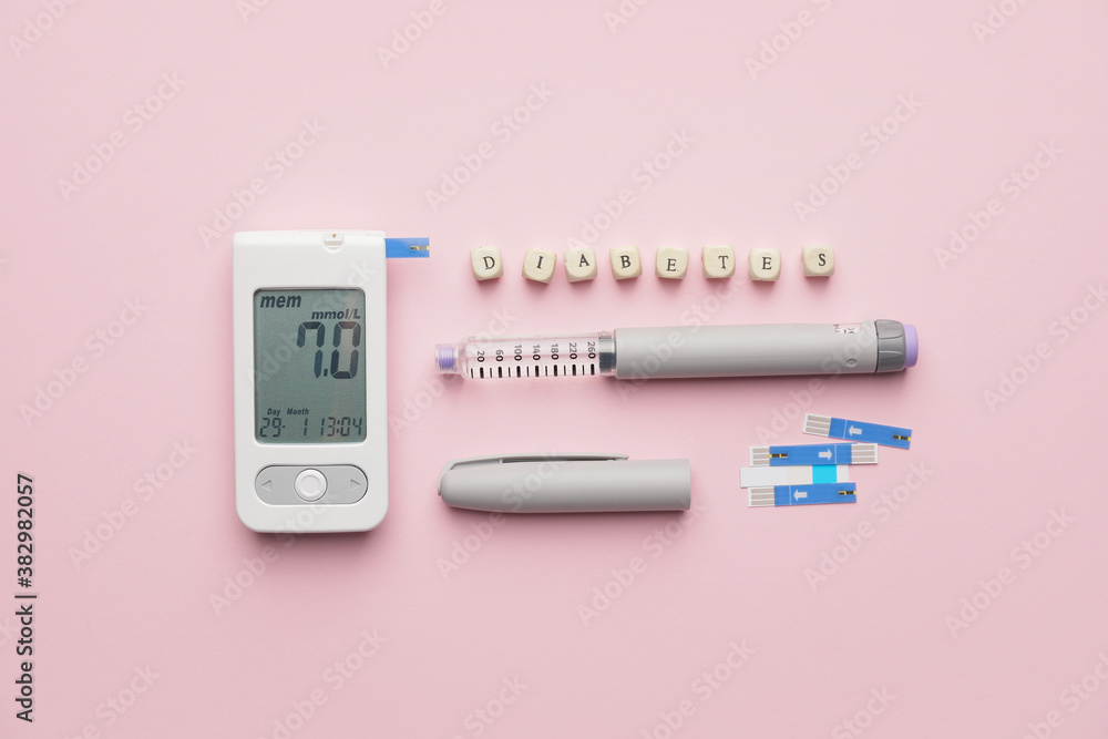 Glucometer, test strips, syringe and word DIABETES on color background Glucometer, test strips, syringe and word DIABETES on color background