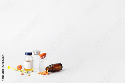 Bottles of insulin with pills and syringe on white background. Diabetes concept