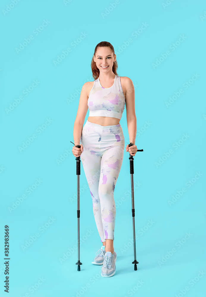 Young woman with walking poles on color background Young woman with walking poles on color background