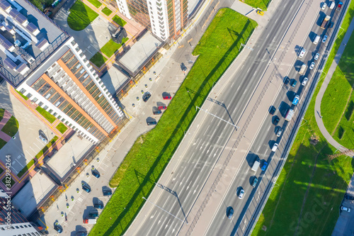 Urban highway car traffic jams with multi-storey buildings, aerial view.