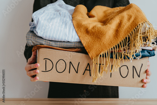 Billede på lærred Woman holding cardboard donation box full with clothes