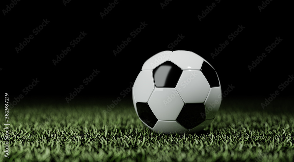 Soccer ball on the lawn of a soccer field, isolated on black background
