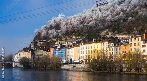 Image of cable cars over river and bridge in Grenoble in autumn, France