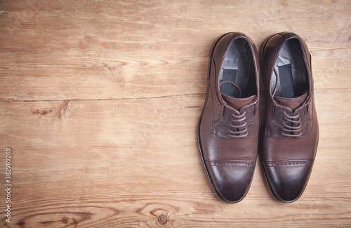 Brown shoes on the wooden background.