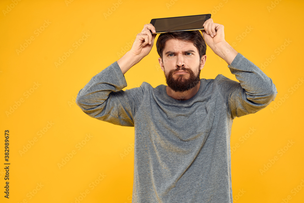 Bearded man with tablet in hands technology work wireless device yellow background