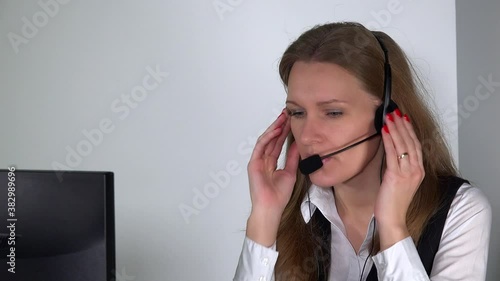 consultant working with headphones on tedious work at computer in office.