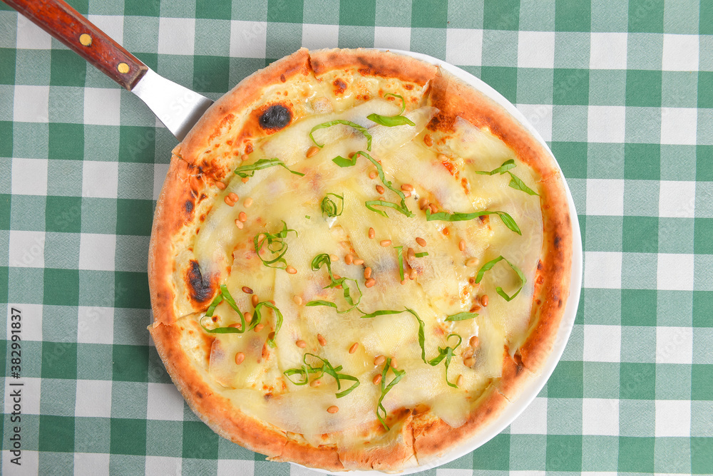 Pear and cheese pizza over green plaid table cloth. Delicious unique recipe. Traditional Italian cuisine Italian concept Pear and cheese pizza over green plaid table cloth. Delicious unique recipe. Traditional Italian cuisine Italian concept