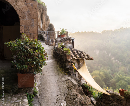 Valley view in the mist from the mountainous street in the medieval commune town of Calcata in Italy depopulated in 1930th for fear of collapse and then repopulated by artists and hippies in 1960th photo