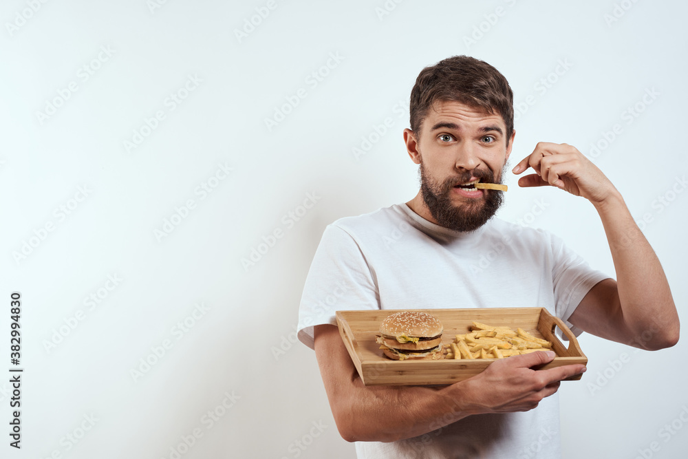 man with wooden tray fries and hamburger fast food calories model white t-shirt man with wooden tray fries and hamburger fast food calories model white t-shirt