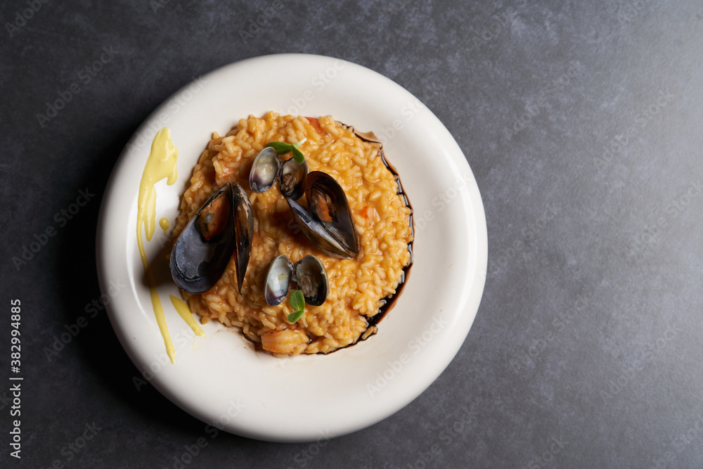 Risotto with mussels and rice in a white plate. Spanish cuisine, Seafood Paella Risotto with mussels and rice in a white plate. Spanish cuisine, Seafood Paella