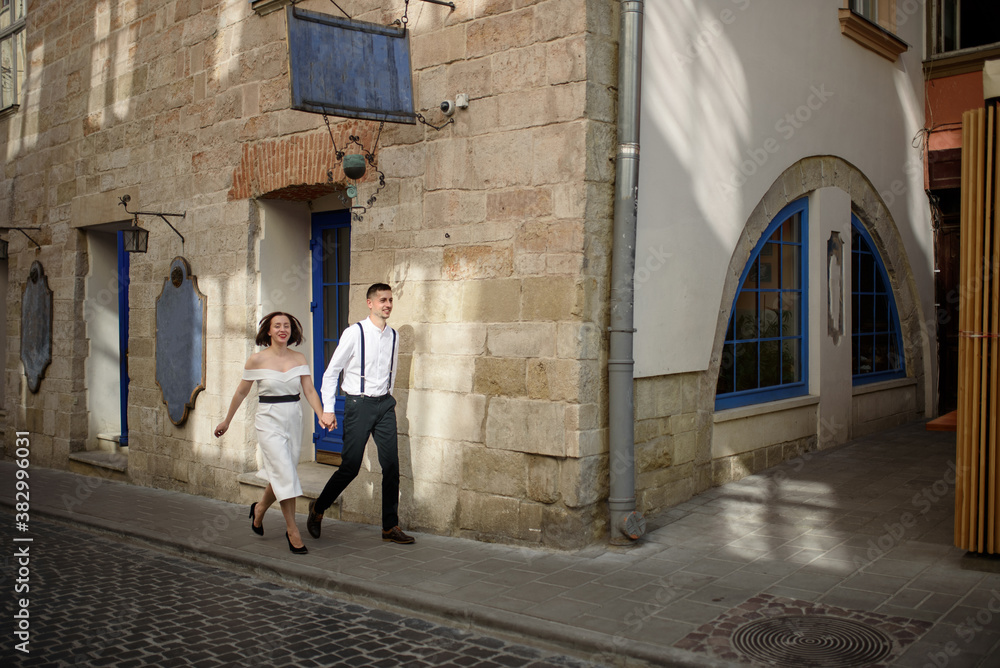 Beautiful stylish couple walking along the street of the old city on a date.