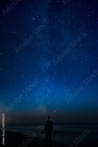Fototapeta Naklejka Na Ścianę i Meble -  Adventurous man watching the stars on a beach at night. 