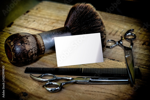 Various hairdressing scissors with brush and hair comb, with white business card for mock-up