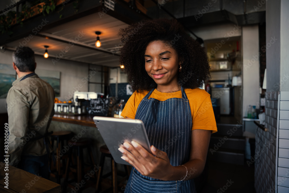 Smiling waitress choosing meal option for customer scrolling on digital tablet in trendy cafe Smiling waitress choosing meal option for customer scrolling on digital tablet in trendy cafe