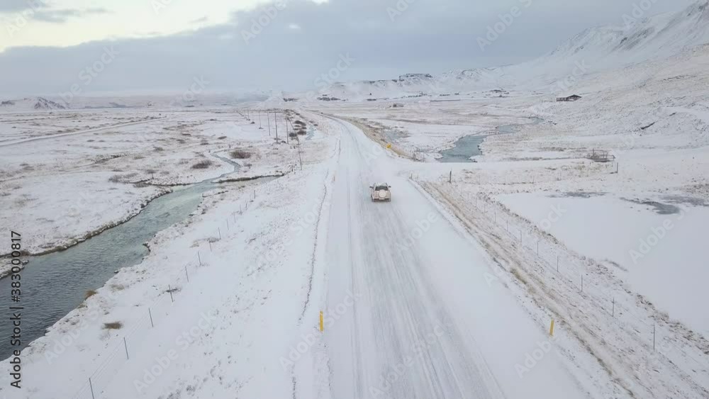 A Car driving on a long road through iceland's loneliness in the winter A Car driving on a long road through iceland's loneliness in the winter