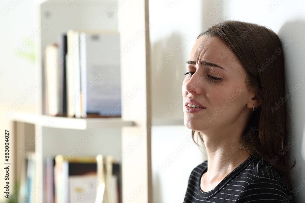 Depressed woman crying alone at home
