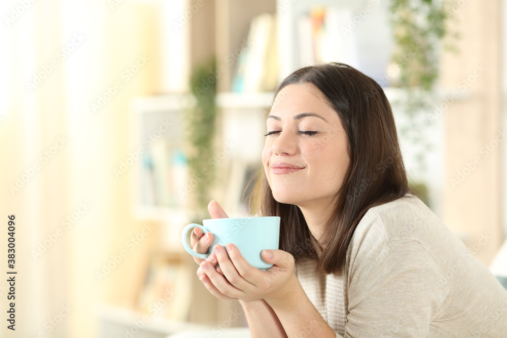 Satisfied woman relaxing holding coffee mug at home Satisfied woman relaxing holding coffee mug at home