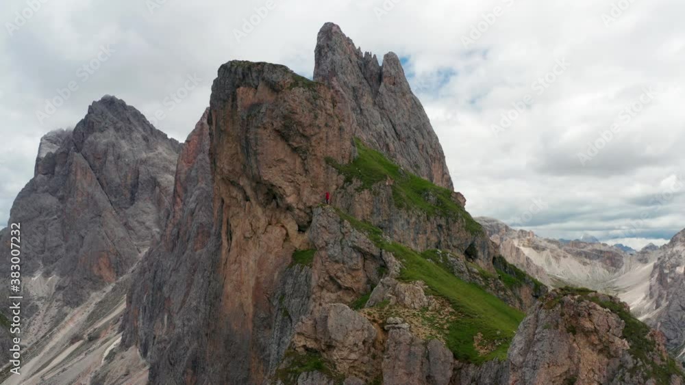 Italian Dolomites, Jagged peaks of Seceda. Man Stands at Cliff Edge Italian Dolomites, Jagged peaks of Seceda. Man Stands at Cliff Edge