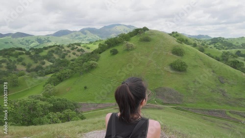 Young Female Hiker Taking a Break From the Hiking Trail In the Green Hills of California photo