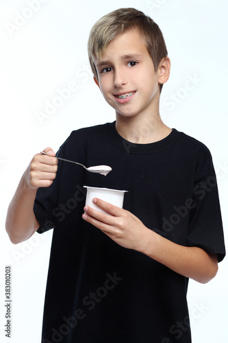 Boy eating yogurt isolated on white background