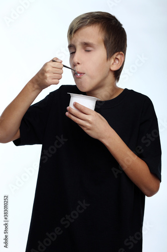 Healthy happy boy eating yogurt