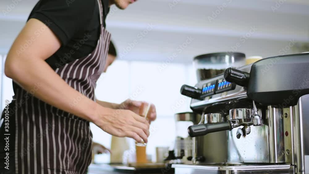 Pouring coffee stream from professional machine in cup. Barista man making double espresso, using filter holder. Flowing fresh ground coffee. Drinking roasted black coffee in the morning Pouring coffee stream from professional machine in cup. Barista man making double espresso, using filter holder. Flowing fresh ground coffee. Drinking roasted black coffee in the morning
