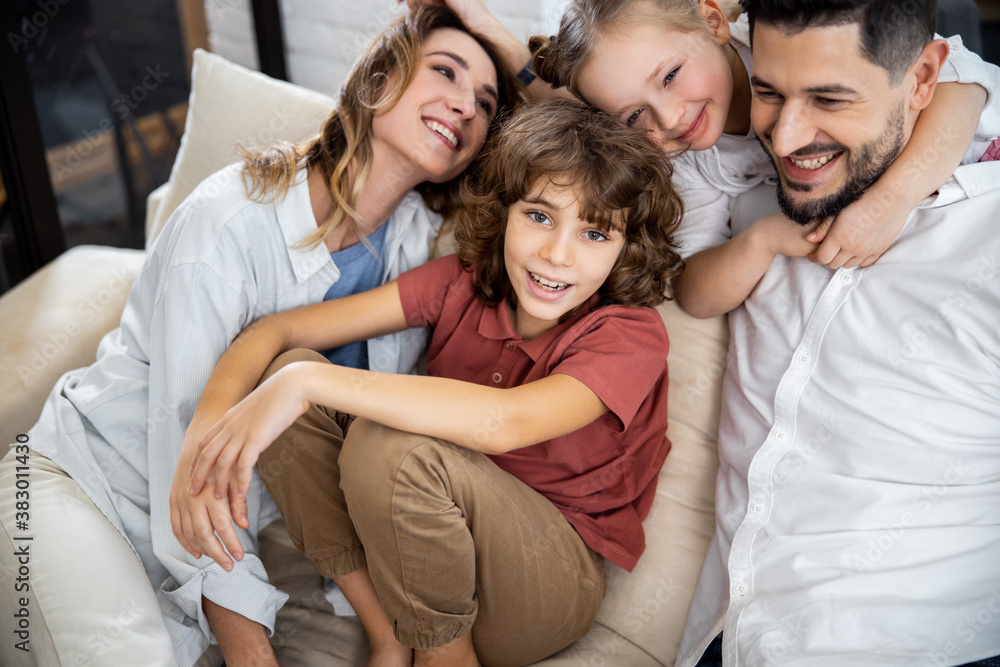 Family with kids laughing while sitting on couch Family with kids laughing while sitting on couch