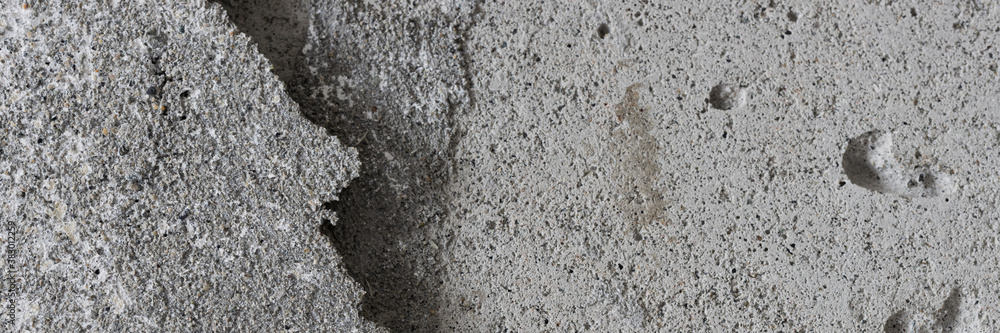 Texture of an old cracked concrete wall. Grungy gray concrete surface with shadow. Wide panoramic background for design. Texture of an old cracked concrete wall. Grungy gray concrete surface with shadow. Wide panoramic background for design.