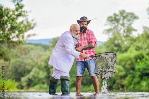 granddad and drandson fishing. fisher celebrate retirement. good production. Fishermen. successful catch. hobby and recreation. Success. retired businessman. male friendship. Good profit photo