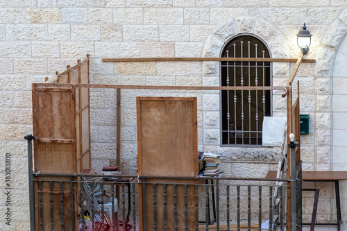 A wooden sukkah on the balcony of a synagogue, before the Jewish Sukkot holiday. Construction that allows the flow of air to prevent infection in the corona photo