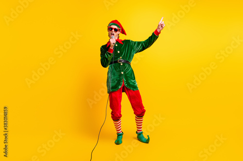 Full length body size view of his he nice attractive cool cheerful cheery funny guy elf singing song festal day occasion isolated over bright vivid shine vibrant yellow color background