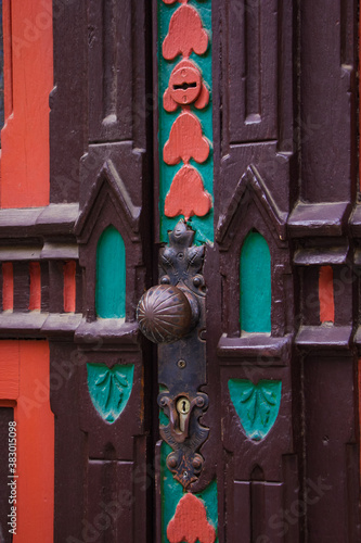 Vintage dark red antique double door in Paris. Round handle on aged wood surface. vertical orientation. photo