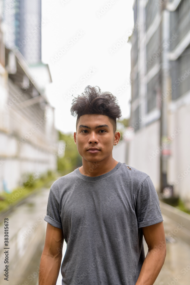 Young Asian man with curly hair in the streets outdoors Young Asian man with curly hair in the streets outdoors